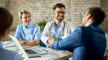 happy doctor shaking hands with a businessman on a meeting in th