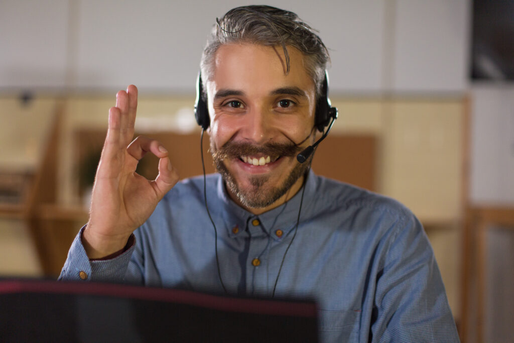 happy call center operator looking at camera and showing ok sign